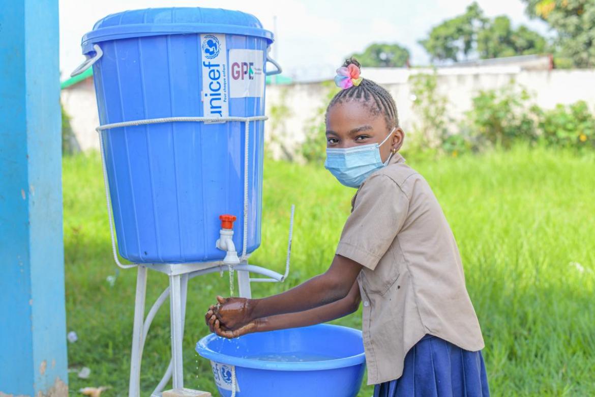 Angela, 10 ans, se lave les mains avant d'entrer en classe à l’école primaire Sébastien Mafouta. Crédit : UNICEF/2021/MARANATHA
