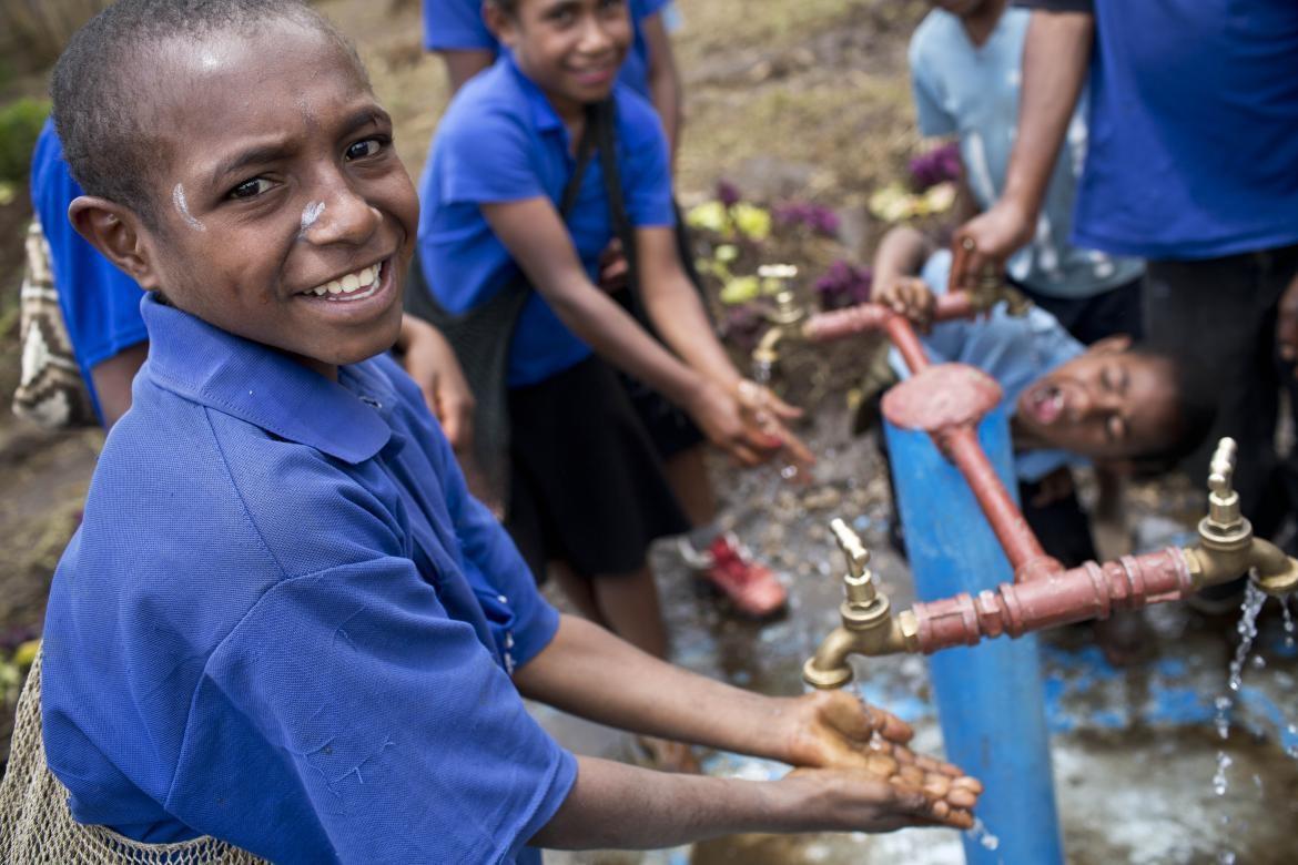 Des enfants montrant comment se laver les mains à Karin Hulshof, directrice régionale de l'UNICEF pour l'Asie de l'Est et le Pacifique, lors d'une visite d’une école à Topa dans la ville de Mendi en Papouasie-Nouvelle-Guinée, le jeudi 14 mars 2019. Crédit : Kateholtphoto