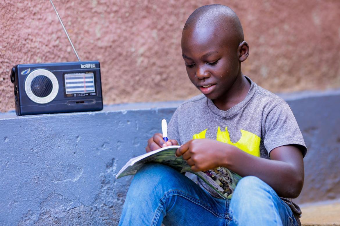 Igihozo Kevin, 11 ans, élève au CM1, étudie en écoutant quotidiennement ses cours à la radio depuis la maison à cause des fermetures d'écoles dues à la pandémie de coronavirus. Crédit : UNICEF